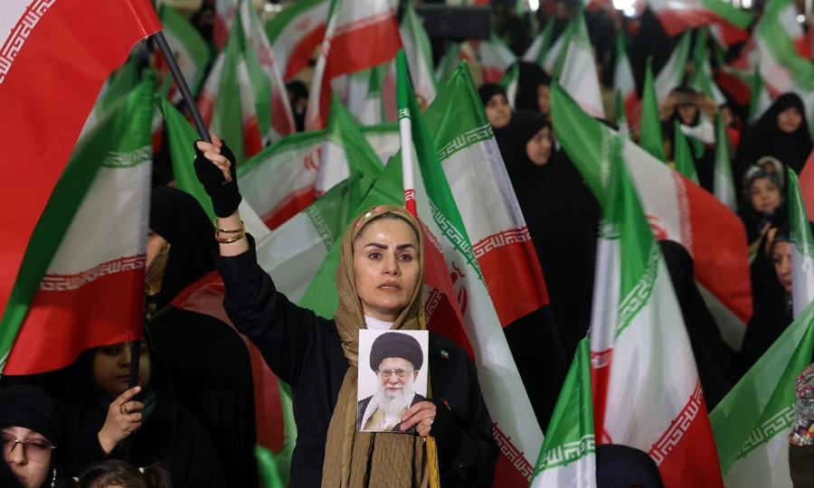 Mulher iraniana acena com a bandeira nacional do Irã enquanto segura uma foto do líder supremo iraniano, aiatolá Ali Khamenei, durante uma cerimônia em memória dos mortos em protestos antigoverno ocorridos no início do mês passado (Foto: EFE/EPA/ABEDIN TAHERKENAREH)